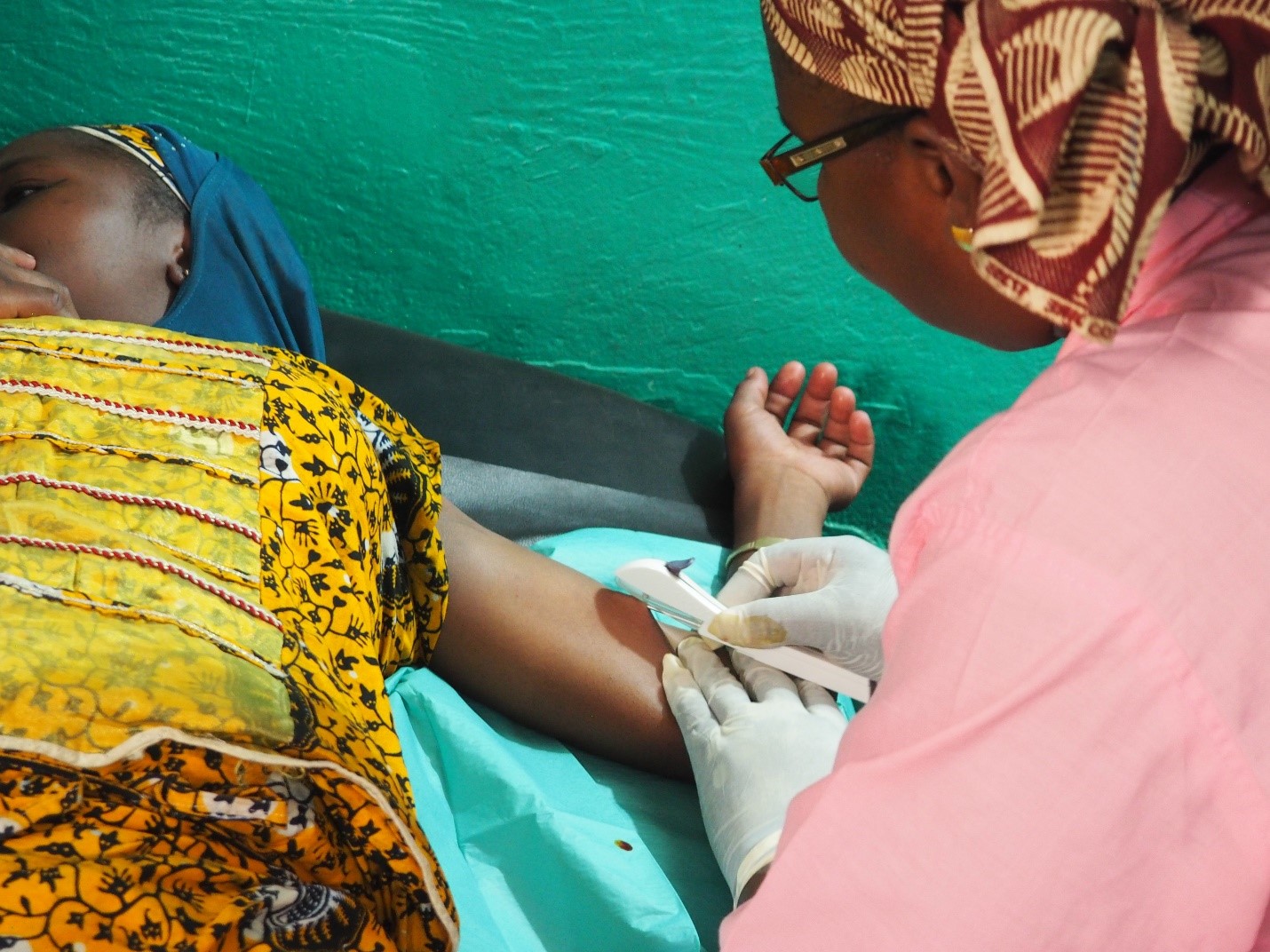 Midwife Fatoumata Coulibably inserts a three-year implant into Massaran's arm. Credit: David J. Olson